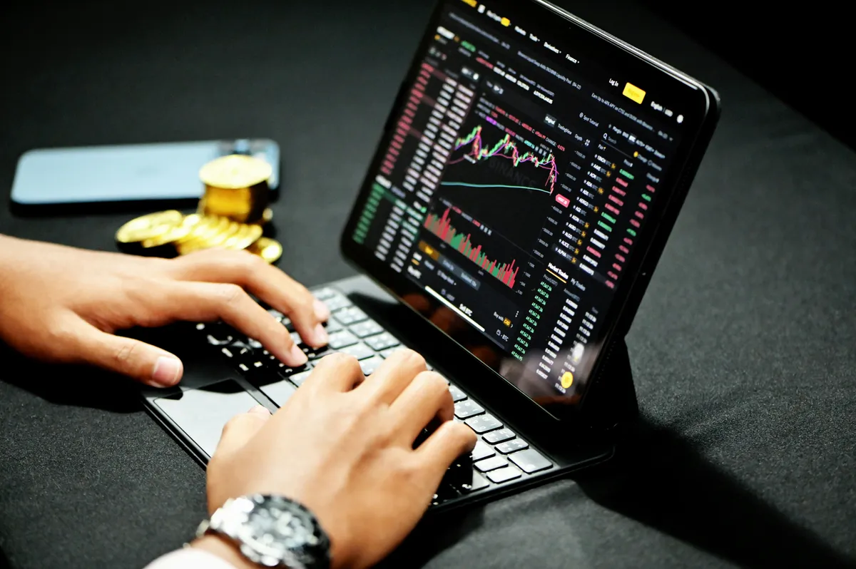 Laptop with markets monitor and charts. (Kanchanara/Unsplash)